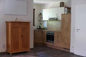 a kitchen with wooden cabinets and a stove top oven at Räuberlager 15 in Dammbach