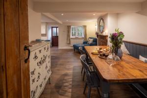 a kitchen and living room with a wooden table at Gardener's Cottage in Dorchester