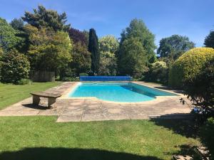 a swimming pool with a bench in a yard at Gardener's Cottage in Dorchester