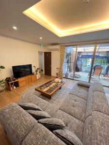sala de estar con sofá y mesa en Resort Villa 海結-umiyui-, en Onna