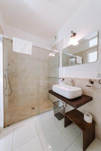 a white bathroom with a sink and a shower at Lamare cucina e dimore in Polignano a Mare +37 photos