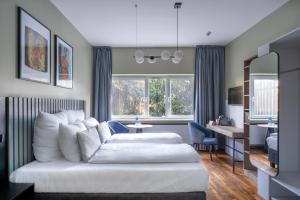 a bedroom with a white bed and a living room at Numa Bona in Bonn