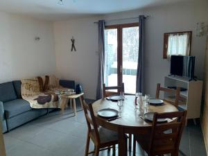 a living room with a table and a couch at Appartement Matiski in Vaujany