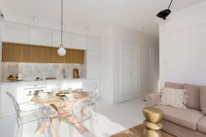 a kitchen and living room with a table and a couch at Bursztynowe Tarasy - Apartamenty in Gdańsk