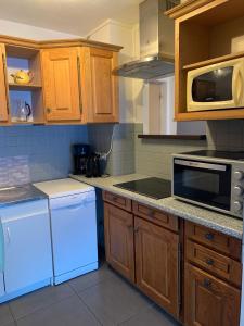 a kitchen with white appliances and wooden cabinets at Appartement Matiski in Vaujany