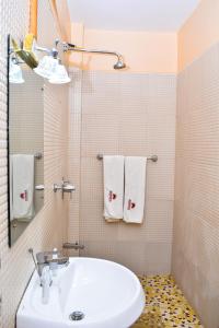 uma casa de banho com lavatório, WC e toalhas em Breeze Hotel Nyahururu em Nyahururu
