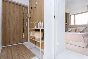 a small bedroom with a bed and a closet at Bursztynowe Tarasy - Apartamenty in Gdańsk
