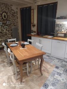 カンカルにあるLe Cati Miniのキッチン(木製テーブル、白い椅子付)