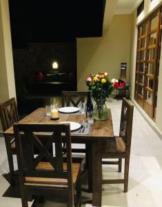 a wooden table with chairs and a vase of flowers at C9 @ Diani Beachalets in Galu