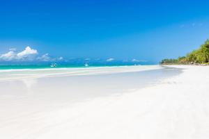 a beach with white sand and the ocean at C9 @ Diani Beachalets in Galu