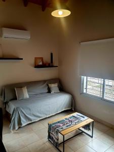 1 dormitorio con cama, mesa y ventana en Casa Drummond-Luján de Cuyo en Luján de Cuyo