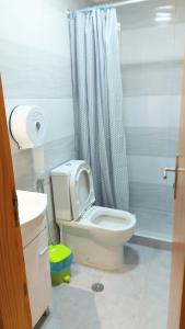 a white bathroom with a toilet and a shower at Residencial Condado in Faro
