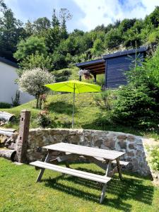 a picnic table with a yellow umbrella in the grass at Gite "Lili" in Lapoutroie