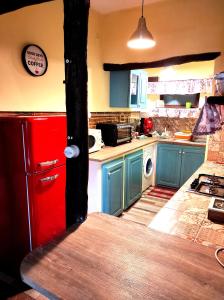 - une cuisine avec des armoires bleues et un réfrigérateur rouge dans l'établissement IL Vicoletto, à Serra San Bruno