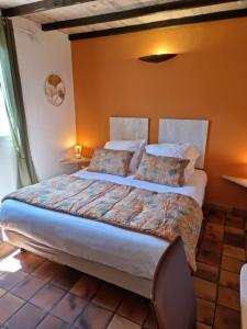 a bedroom with a large bed with orange walls at Logis Hôtels Le Saint Marc in Mollans-sur-Ouvèze