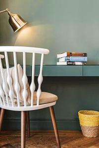 a white chair sitting in a room with a desk at Olive Gordon By The Beach in Tel Aviv