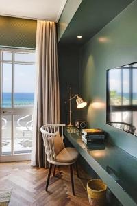 Zimmer mit einem Schreibtisch mit einem Spiegel und einem Stuhl in der Unterkunft Olive Gordon By The Beach in Tel Aviv