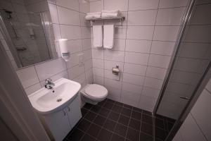 a white bathroom with a toilet and a sink at Førde Gjestehus og Camping in Førde
