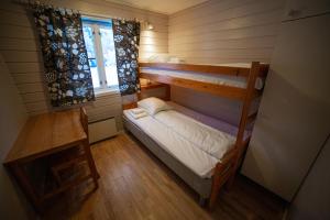 フェールデにあるFørde Gjestehus og Campingの二段ベッド1組、窓が備わる小さな客室です。