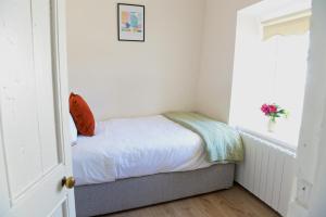 a small bedroom with a bed and a window at Corderry Farmhouse, idyllic cottage amid 250 acres in Stagdale Bridge