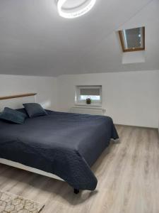 ein Schlafzimmer mit einem großen schwarzen Bett und einem Fenster in der Unterkunft Collot Residence Sibiu 2 in Turnişor