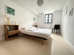 - une chambre blanche avec un lit et une chaise dans l'établissement Résidence Bury, à Tulle