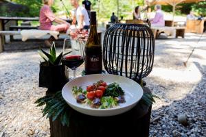 een bord eten en een fles wijn en een glas bij Buitenplaats Beekhuizen in Velp