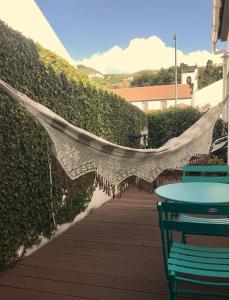 a hammock on a patio with a hedge at Modern room (with deck) in Povoação