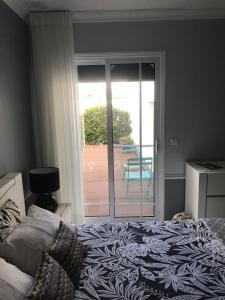 a bedroom with a bed and a sliding glass door at Modern room (with deck) in Povoação