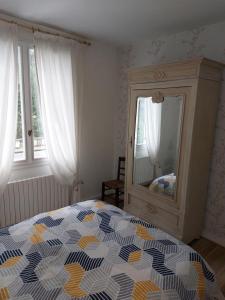 una camera con letto, cassettiera e specchio di maison individuel proche des châteaux et Amboise avec jardin clos a Pocé-sur-Cisse