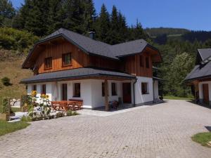 ein großes Holzhaus mit einer Ziegelsteinfahrt in der Unterkunft Ferienhaus Soghäusl in Göstling an der Ybbs