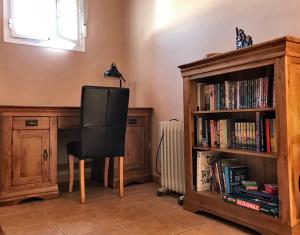 una silla negra sentada junto a un estante de libros en Casa Uno - Your home in the heart of Andalucia, en Córdoba