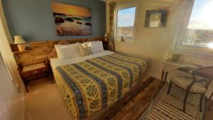 1 dormitorio con cama, escritorio y ventana en Garvault House en Kinbrace
