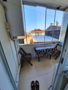 伊斯坦堡的住宿－Tarabya Family Suit Acibadem Hospital，阳台配有桌子和长凳