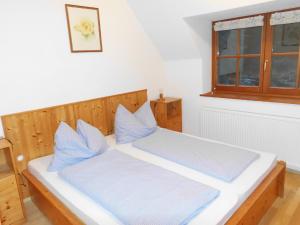 een slaapkamer met een bed met blauwe kussens bij Ferienhaus Soghäusl in Göstling an der Ybbs