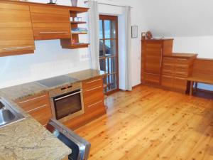 a kitchen with wooden cabinets and a wooden floor at Ferienhaus Soghäusl in Göstling an der Ybbs