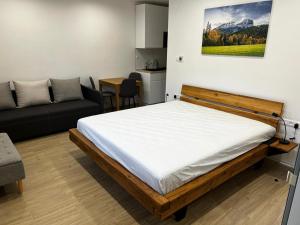 een slaapkamer met een groot bed en een bank bij Apartment house Tatras in Liptovský Mikuláš