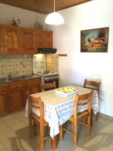 a kitchen with a table with chairs and a sink at ARISTIDIS Apartments in Lefkimmi +47 photos