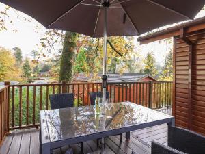 a table with an umbrella on a deck at Treetops in Windermere