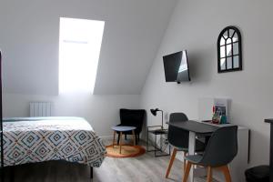 1 dormitorio con 1 cama, mesa y sillas en Location Tame en Douai