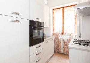 eine Küche mit weißen Schränken und einem schwarzen Gerät in der Unterkunft Navona Home in Rom + 4 Fotos