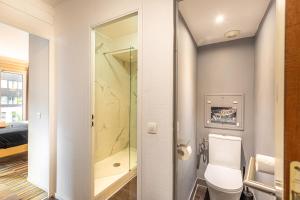 a bathroom with a toilet and a shower at Paris Expo Apart Hotel - Porte de Versailles - 2R & Parking in Issy-les-Moulineaux +14 photos