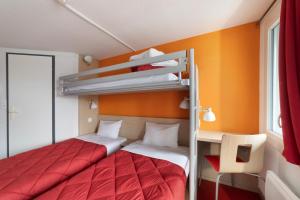 a bedroom with two bunk beds and a desk at Premiere Classe Fleury Merogis in Fleury-Mérogis