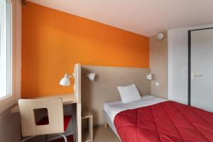 a small bedroom with a bed and a desk at Premiere Classe Fleury Merogis in Fleury-Mérogis