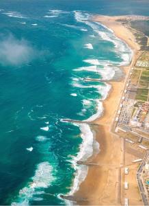 eine Luftansicht auf einen Strand und das Meer in der Unterkunft Open Home - Lisbon/Almada in Almada