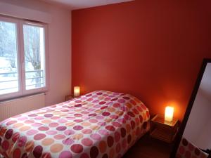 ein Schlafzimmer mit einem Bett mit einer Polka-Punktdecke in der Unterkunft Apartment In Allemont in Allemont