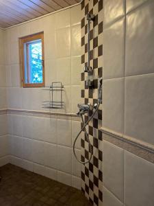 a bathroom with a shower with a tile wall at Villa Joutsen in Hollola