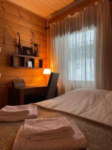 Schlafzimmer mit einem Bett, einem Schreibtisch und einem Fenster in der Unterkunft Villa Joutsen in Hollola