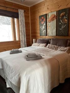 a bedroom with a large bed with towels on it at Villa Joutsen in Hollola