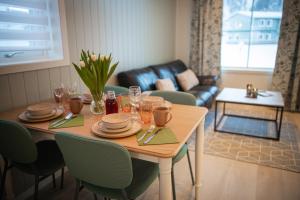 a dining room table with chairs and a couch at Førde Gjestehus og Camping in Førde